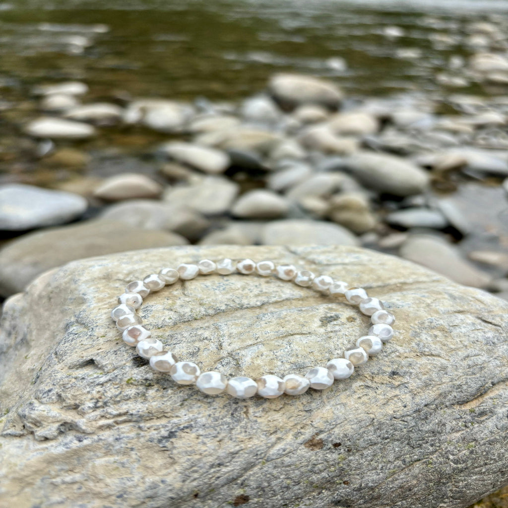 Elastisches Armband aus facettierten Achat-Kugeln (6 mm, 15 cm), energetisiert mit REIKI-Energie; fördert Erdverbundenheit, innere Stärke, Schutz und Harmonie. Jedes Armband ist ein Unikat durch individuelle Steinmuster und spirituelle Aufladung.