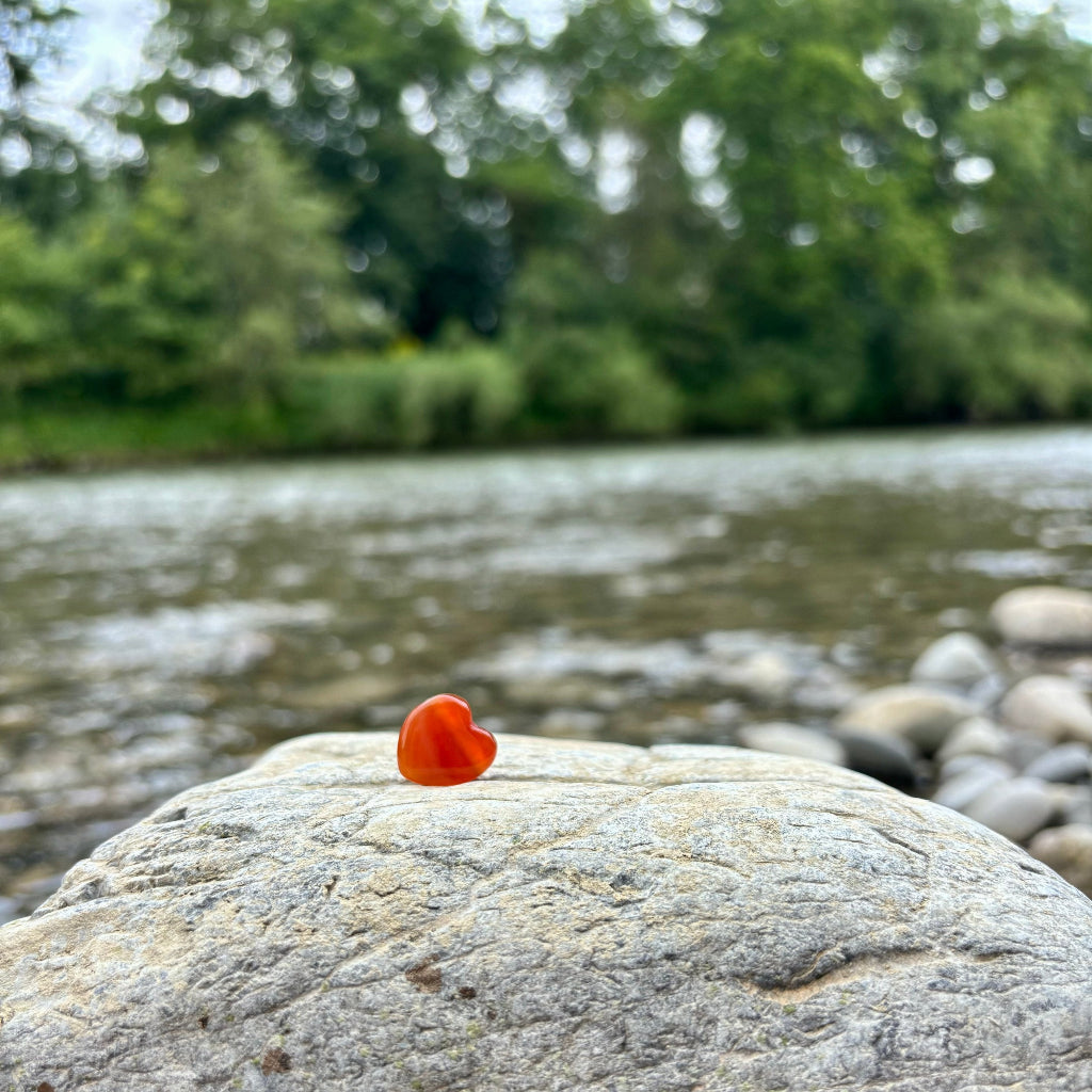 Heilstein-Anhänger in Herzform aus gebohrtem Karneol (1,5 cm), energetisiert mit REIKI-Energie; spiritueller Schmuck zur Förderung von Lebensfreude, Vitalität, Kreativität und emotionaler Balance. Jeder Karneol ist ein Unikat mit individueller Farbgebung und spiritueller Aufladung.