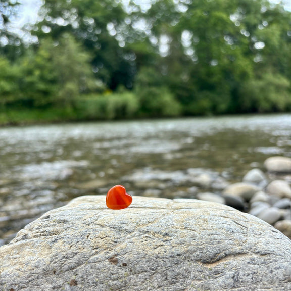 Heilstein-Anhänger in Herzform aus gebohrtem Karneol (1,5 cm), energetisiert mit REIKI-Energie; spiritueller Schmuck zur Förderung von Lebensfreude, Vitalität, Kreativität und emotionaler Balance. Jeder Karneol ist ein Unikat mit individueller Farbgebung und spiritueller Aufladung.